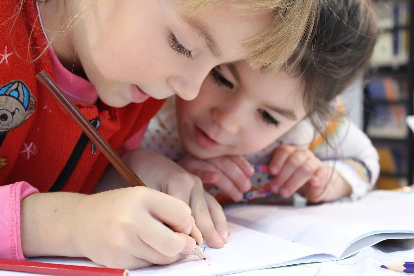 Two children drawing and learning together at a table